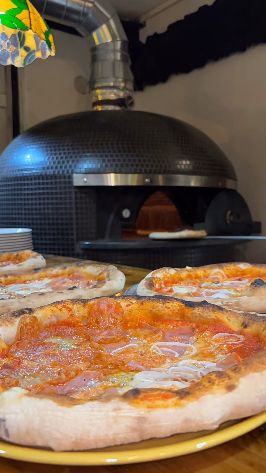 El forn de pedra amb pizzes acabades de sortir